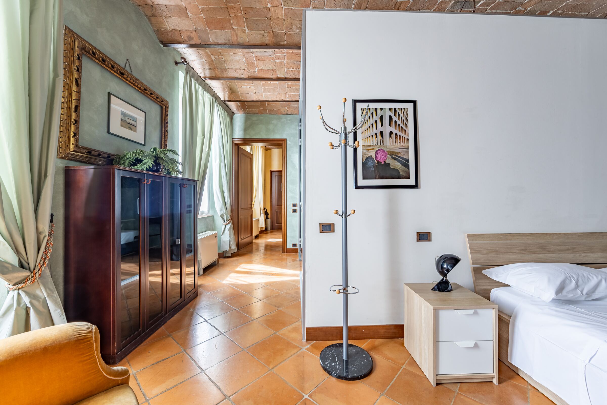La camera matrimoniale vista dall'ingresso, con l'appendiabiti e il mobile in legno