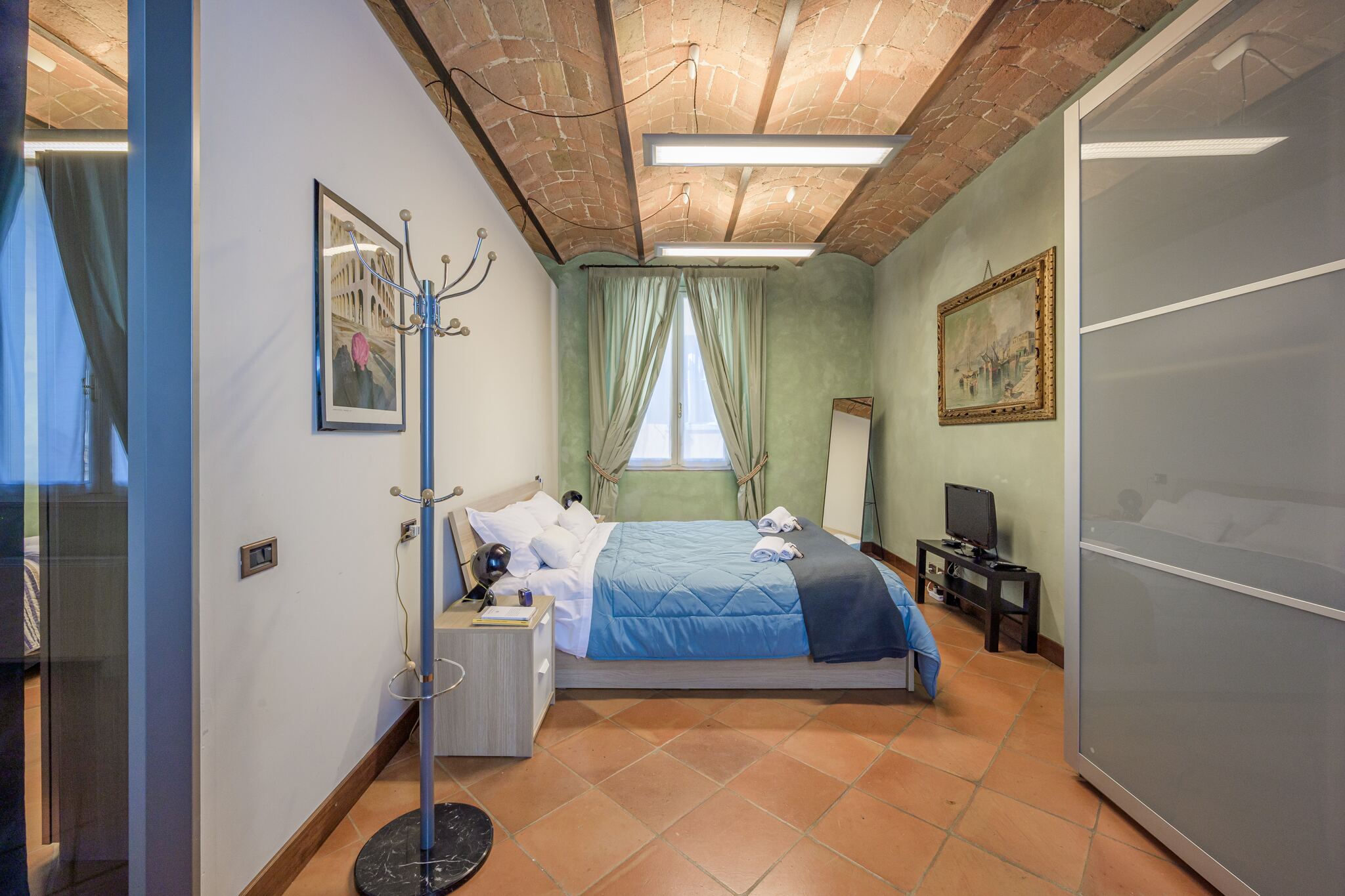 Il letto matrimoniale e l'armadio a ante scorrevoli, sotto le volte in mattoni