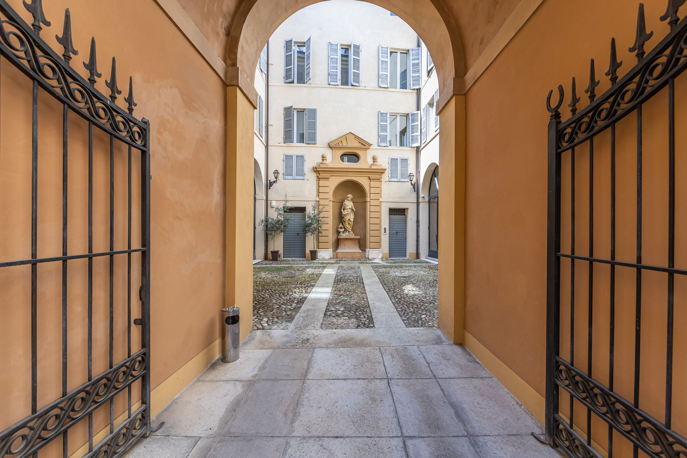 L'androne di Palazzo Montecuccoli visto dal cortile, con l'arco e i cancelli aperti