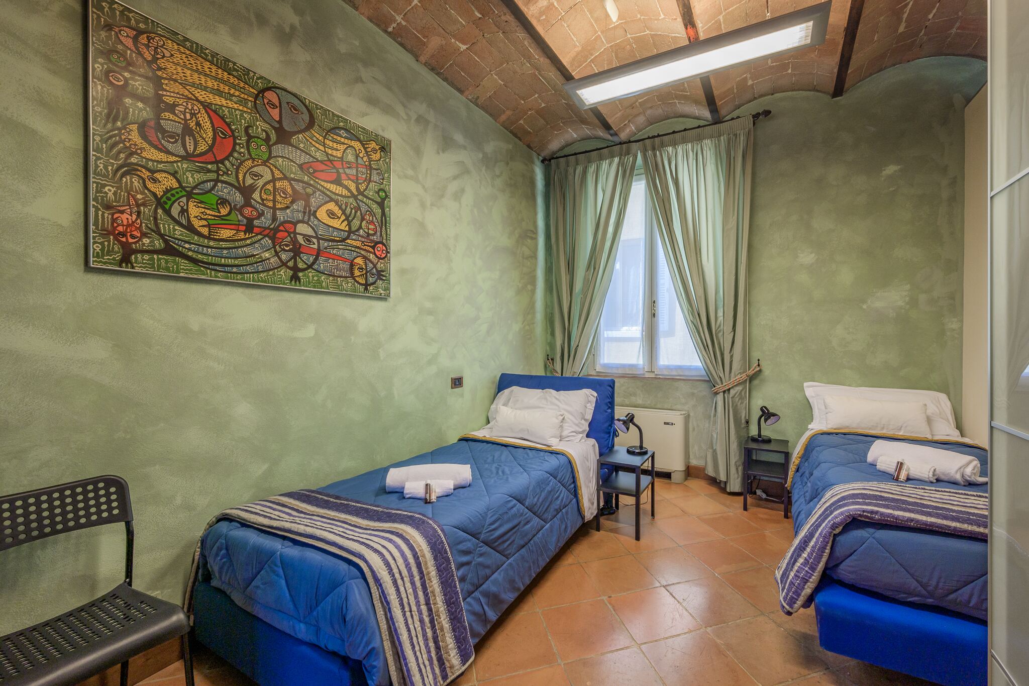 La seconda camera, con due letti singoli e un quadro colorato alla parete