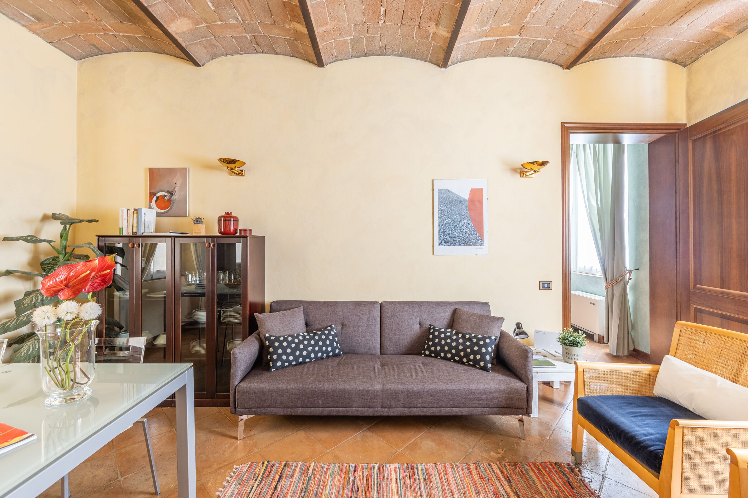Il soggiorno di Modena Palace Suite, con il divano letto sotto le volte in mattoni